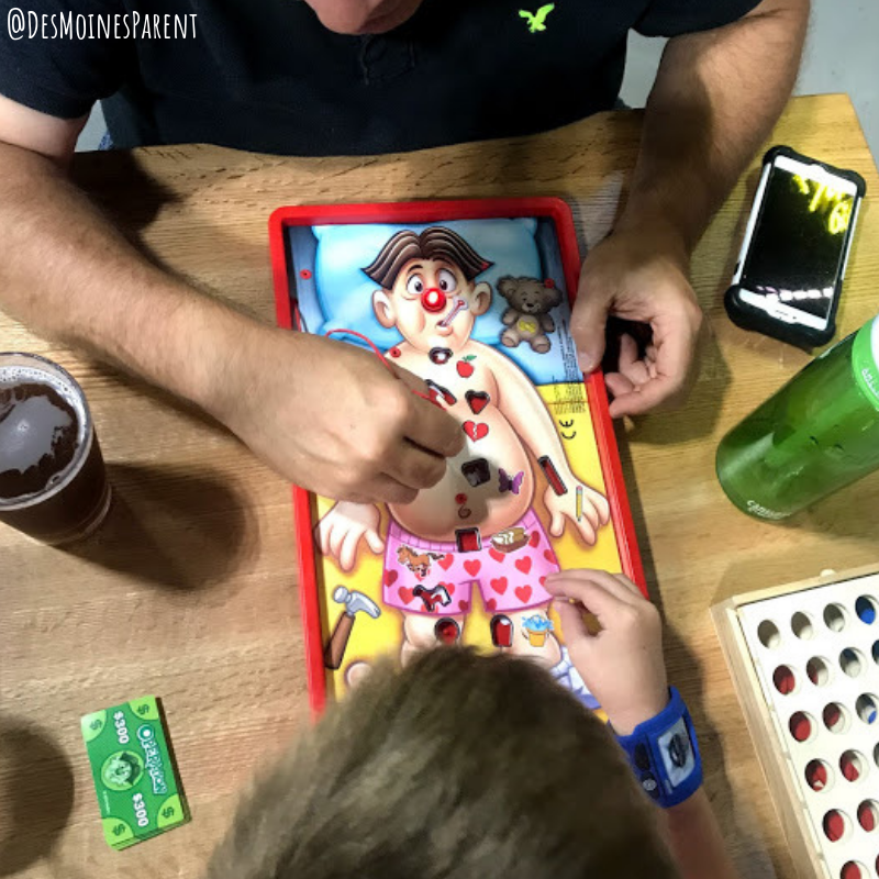 Two people playing the game "Operation."