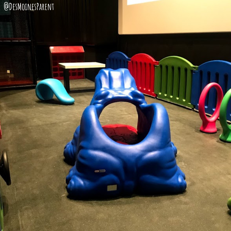Play area for kids in front of movie theater screen.