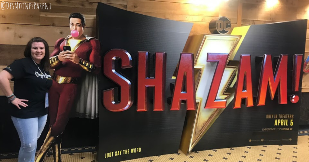 Erin standing next to Shazam display at Branson IMAX theater.